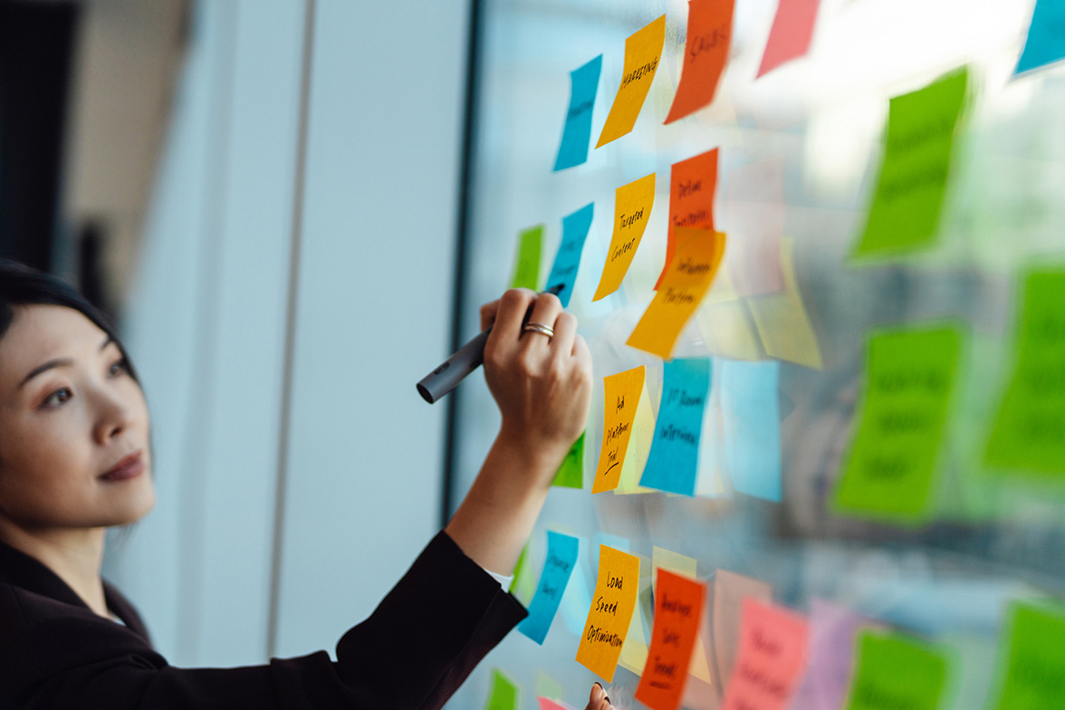 A woman writing on a clear board