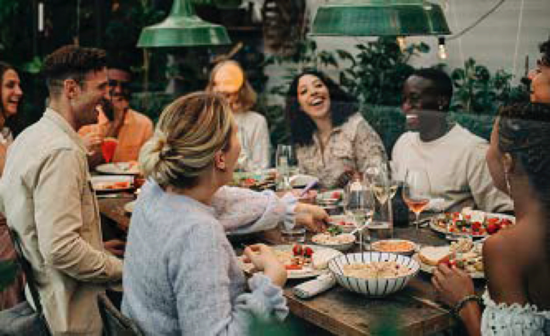 Group of people eating food around a table