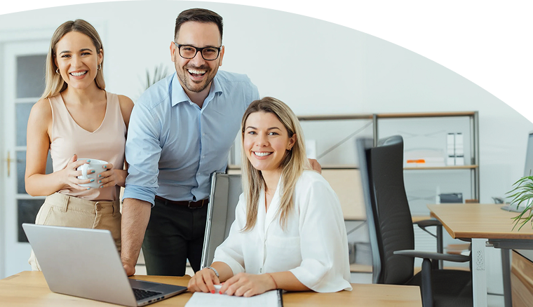 Three colleagues smiling in an office