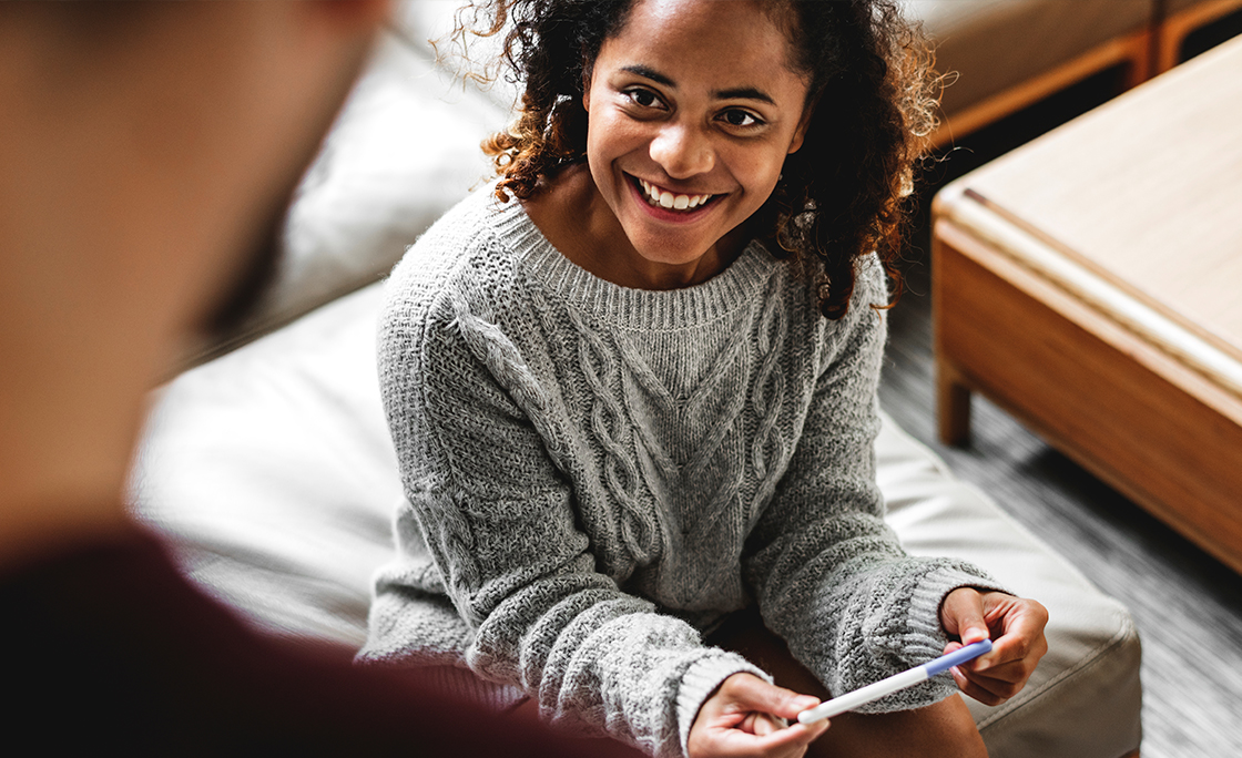 A young woman holding a pregnancy test
