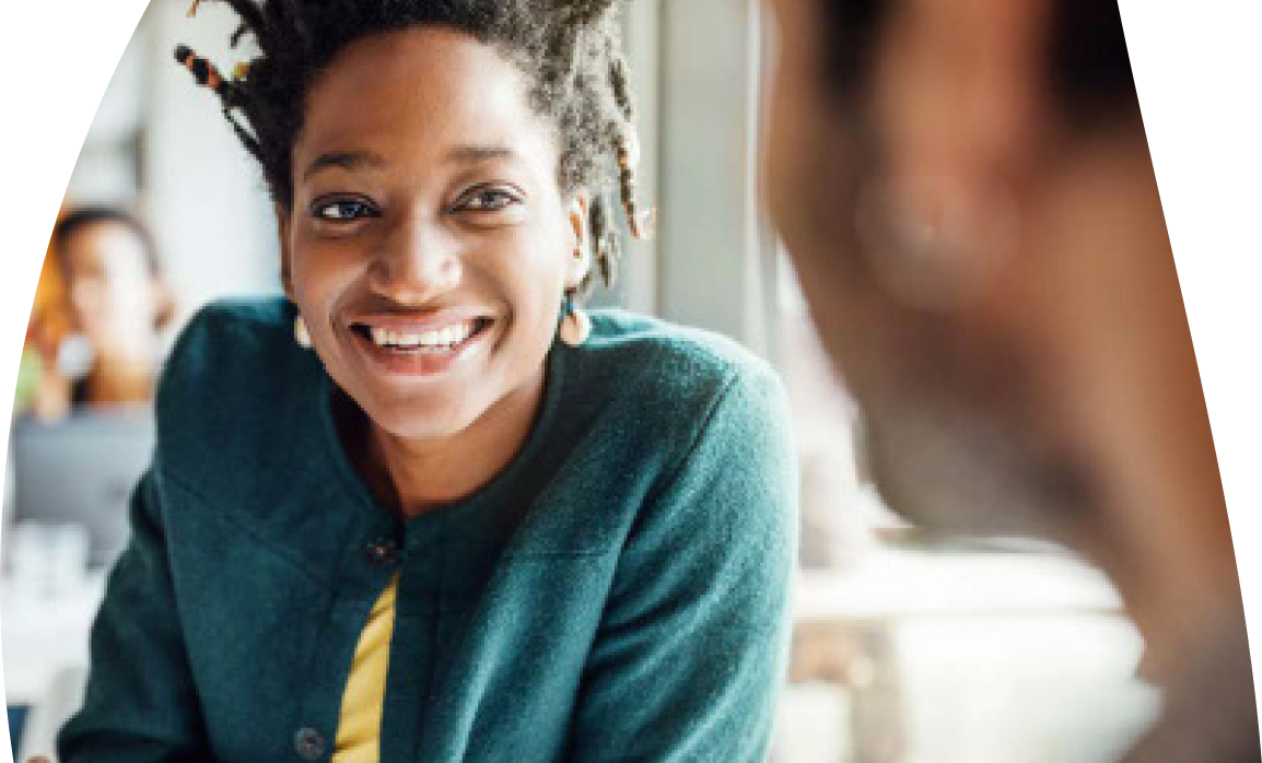 A lady smiling whilst talking to someone