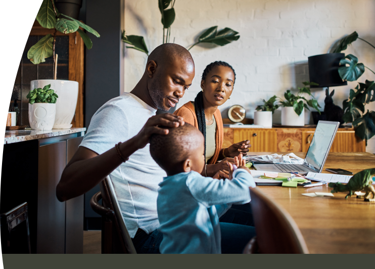 A family sat at a table with a laptop open